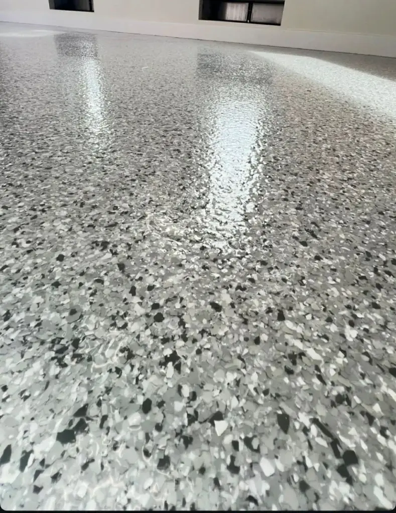 Shiny gray epoxy floor reflecting light in a spacious room
