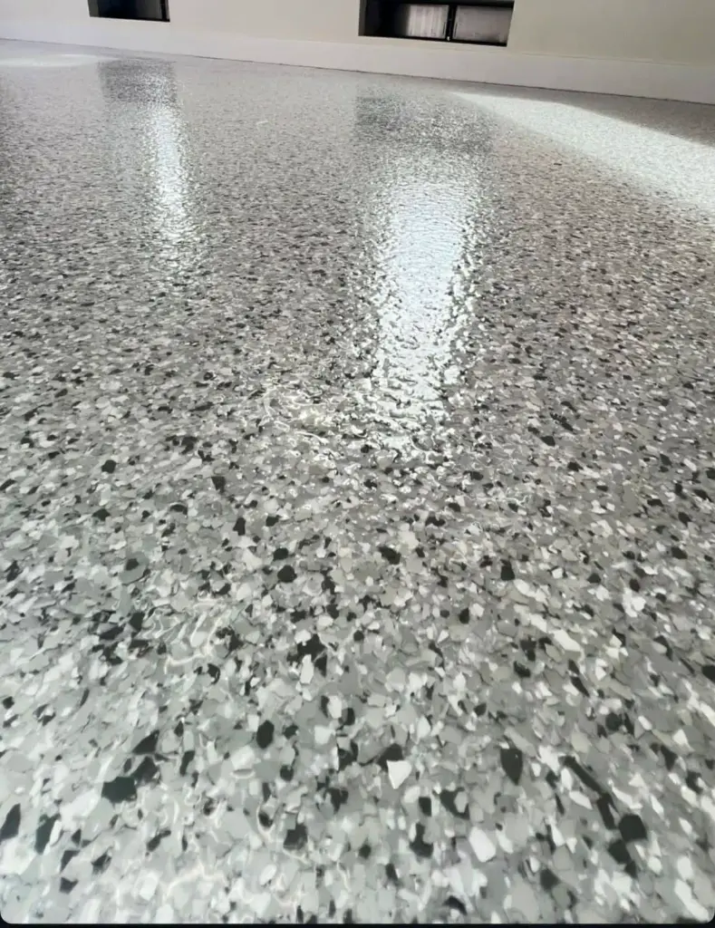 Shiny gray epoxy floor reflecting light in a spacious room